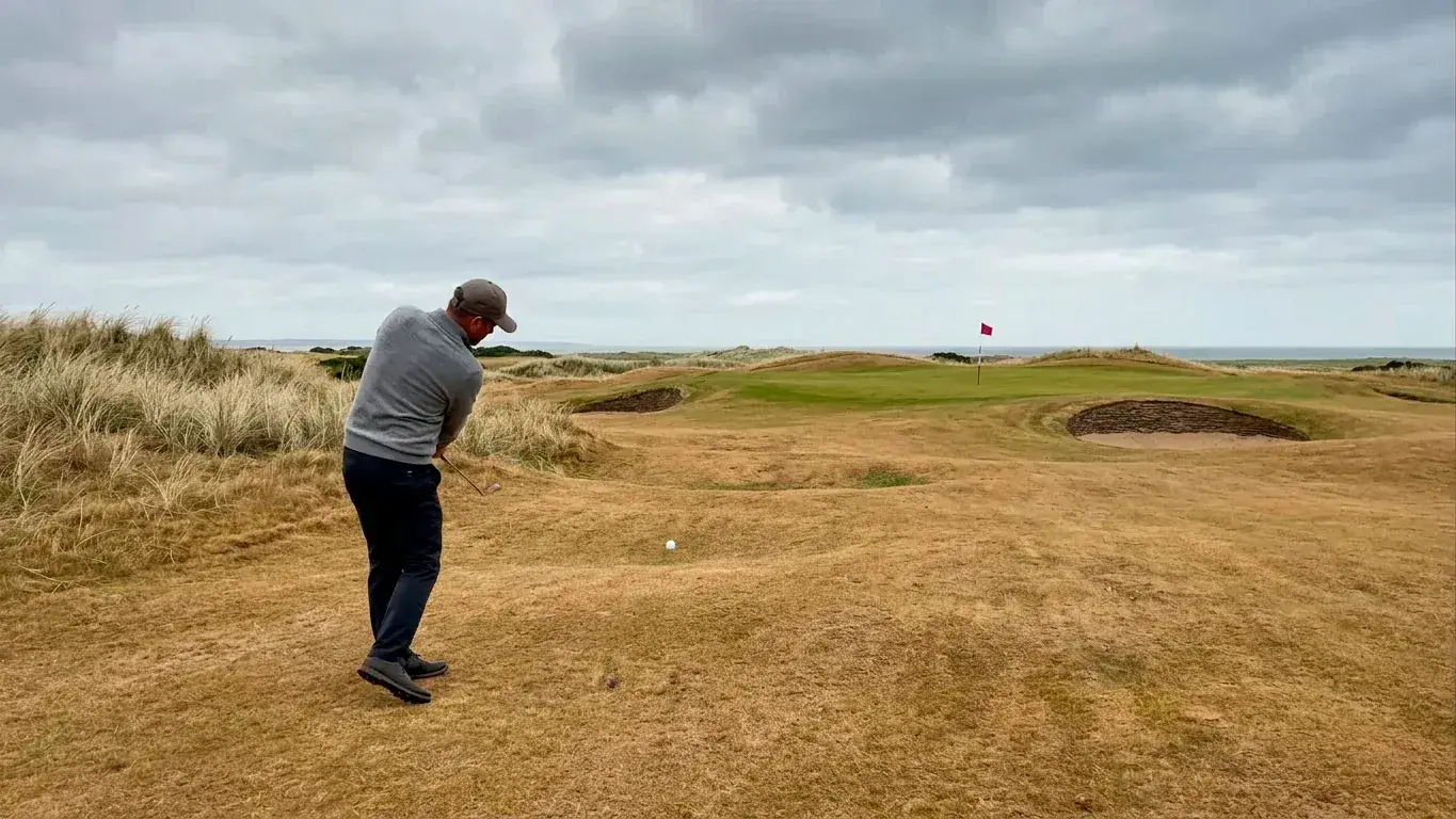 Golfer playing a low bump-and-run approach on firm links turf