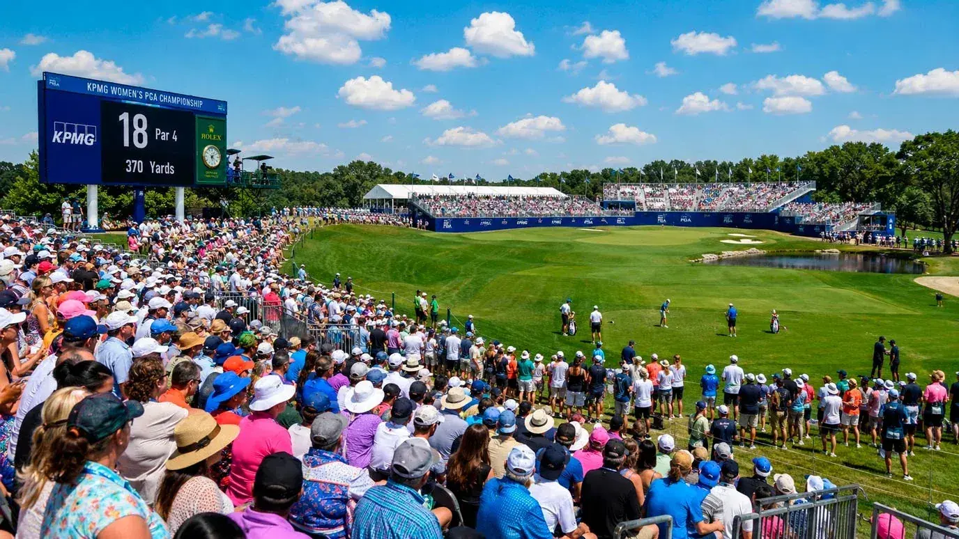 Spectators watching an LPGA major championship with grandstands and branded signage