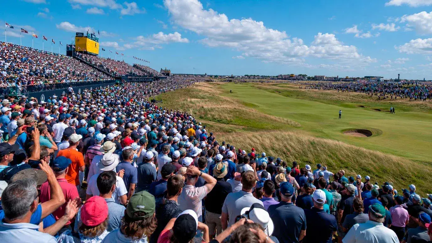 Large crowd gathered at a major golf championship with spectator grandstands and bunting